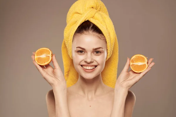 Wanita cantik berpundak oranye di tangan handuk kuning di kepalanya — Stok Foto