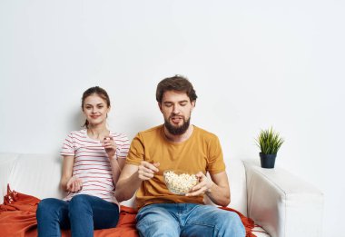 Güzel kadın ve adam kanepede turuncu ekose ve çiçekli bir aşk ailesi.