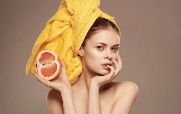 Vacker kvinna med handduk på huvudet bared axlar frukter Exotisk beige bakgrund — Stockfoto