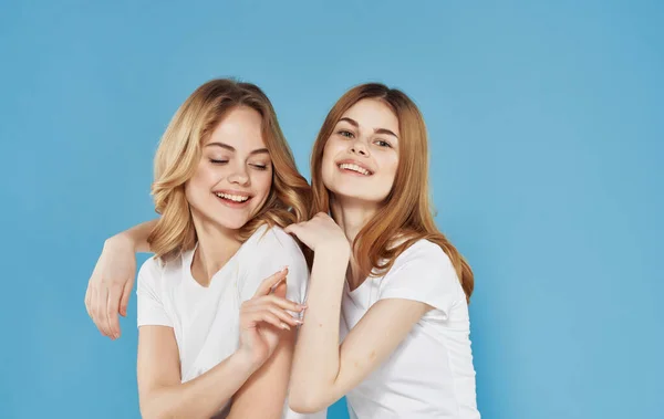 Две смешные девушки в белых футболках весеннее объятие общение — стоковое фото