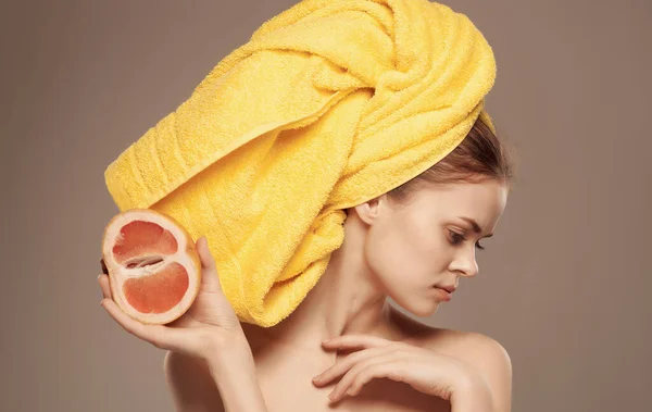 Mulher bonita com toalha na cabeça desnudado ombros frutas Exótico bege fundo — Fotografia de Stock