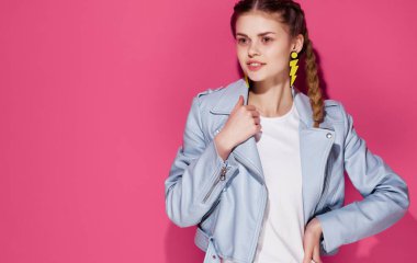 At kuyruklu kadın. Mücevher küpeleri. Pembe arka plan.