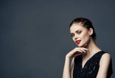 Gri arka plan fotokopisi olan çekici bir kadın el kol hareketi yapıyor.