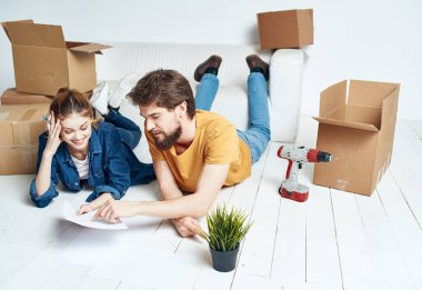 Kadın ve erkek yer tadilatında çalışıyor. Taşınıyor ve alet kutuları taşınıyor.