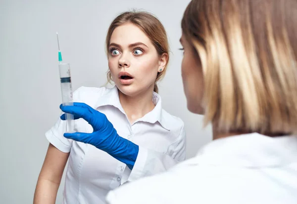 Kvinnlig läkare i blå handskar injektionsspruta kommunikation patient — Stockfoto