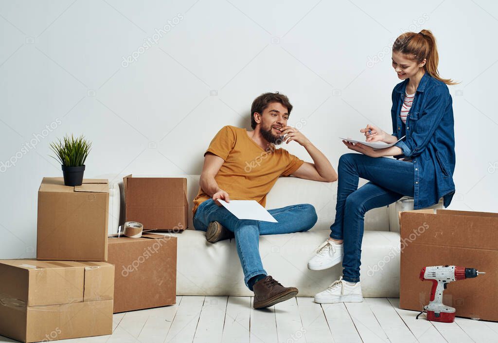 man and woman on white sofa interior cardboard boxes lifestyle