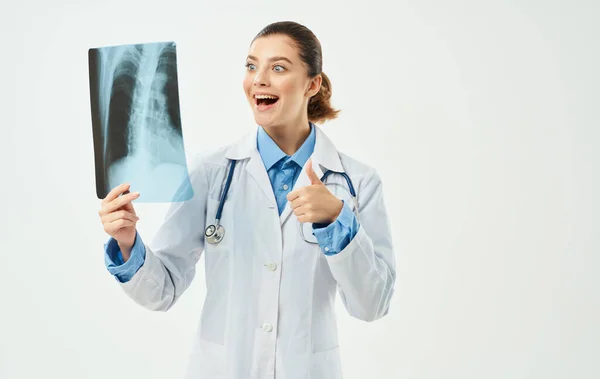 Лікар з рентгенівським та медичним стетоскопом на світлому фоні — стокове фото