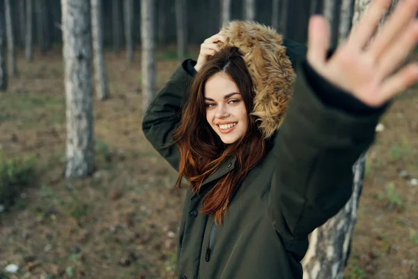 A woman holds her hand above the head of a jacket on nature in the forest — Stock Photo, Image