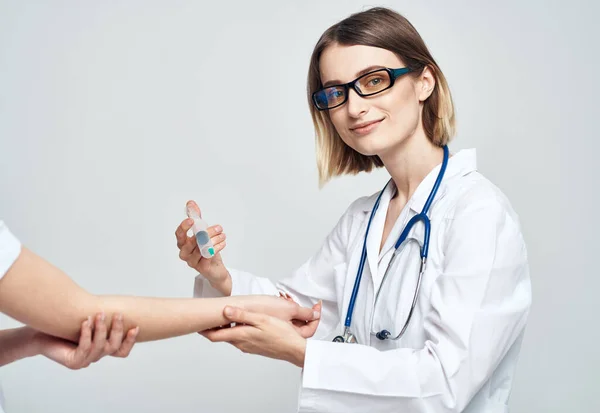 一位穿着医疗服的女医生正在给一位病人注射药物 — 图库照片