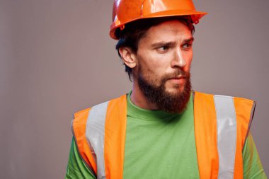 Çalışan üniformalı bir adam turuncu boyalı güvenlik önlemini almış.