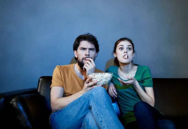 Emotionale Frau und Mann auf der Couch mit Popcorn vor dem Fernseher — Stockfoto