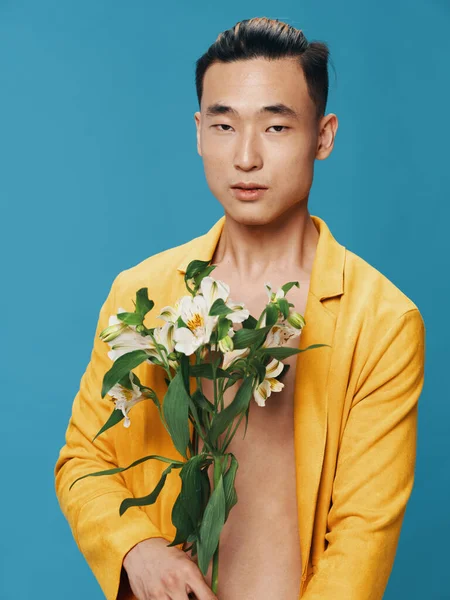 青い背景の肖像画に白い花の花束を持つハンサムなアジアの男 — ストック写真