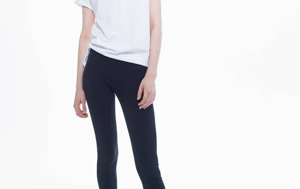 Schwarze Leggings weißes T-Shirt Frau hellen Hintergrund Gesten mit den Händen — Stockfoto
