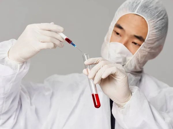 Чоловічий лабораторний технік захисний медичний одяг дослідження розробки ліків сірий фон — стокове фото