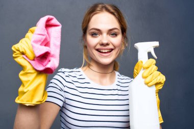 Elinde deterjan bezi olan temizlikçi kadın.