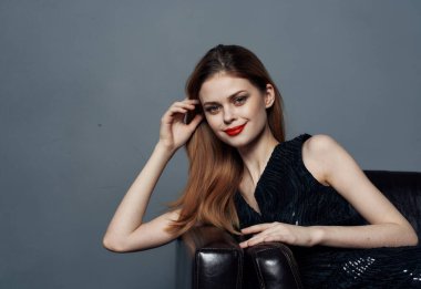 Siyah elbiseli kadın elleri gri arka planda fotokopi uzayında hareket ediyor.