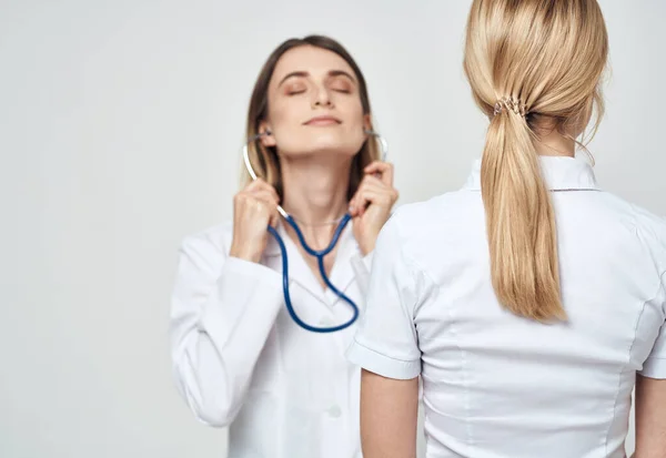 Krankenschwester im Arztkittel Stethoskop und Patientenrückansicht — Stockfoto
