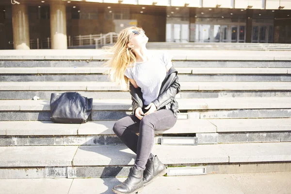 Modello donna si siede sulle scale vicino a un edificio sulla strada in autunno — Foto Stock