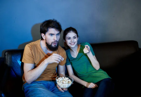 Emotionale Frau und Mann auf der Couch mit Popcorn vor dem Fernseher — Stockfoto