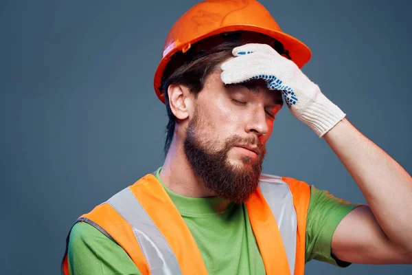 Man in work uniform orange paint safety work fatigue blue background