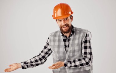 Üniformalı turuncu kasklı inşaat işçisi.