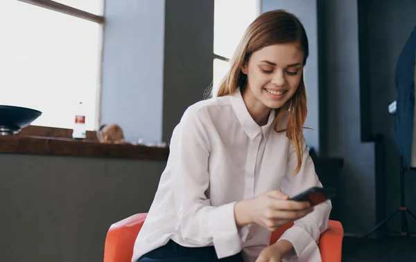 Secrétaire femme s'assoit sur une chaise avec un téléphone dans ses mains Gestionnaire professionnel — Photo