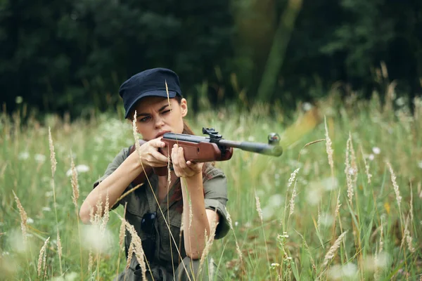 Mujer al aire libre Sentado en el arma de hierba en las manos de una vista de caza al aire libre — Foto de Stock