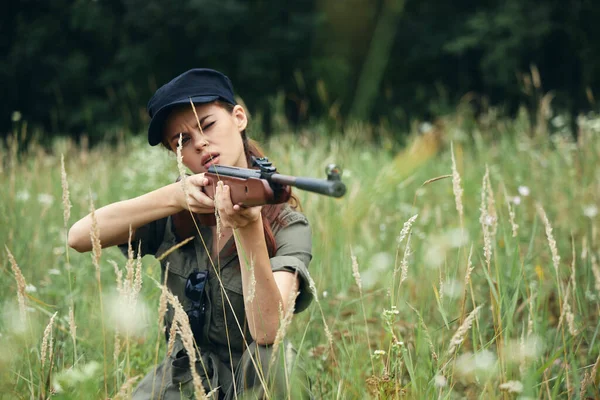 엄호를 위해 앉아 총을 들고 있는 여자 군인 — 스톡 사진