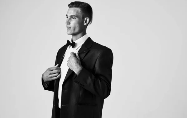 Elegant Gentleman in a suit on a light background black and white photo — Stock Photo, Image