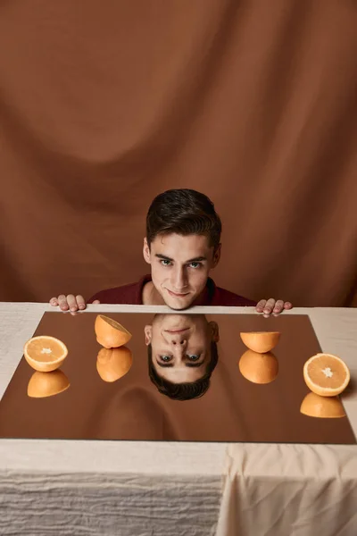 Modell man vid bordet med apelsiner och tyg bakgrund — Stockfoto