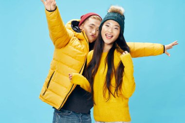 Kışlık giysiler ve eğlenceli aileler giyen genç ve şık bir çift. 