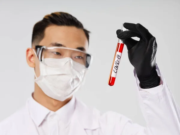 Чоловічий лабораторний асистент азіатського вигляду медична маска дослідження аналізу крові ковід-19 — стокове фото