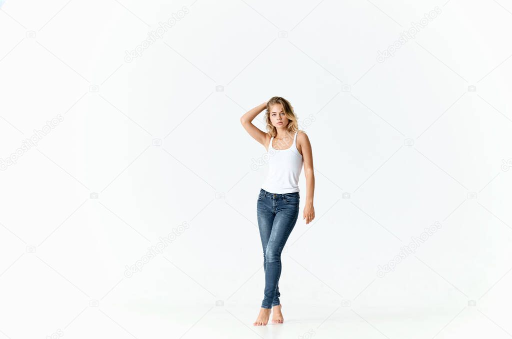woman in full growth on a light background in jeans and a t-shirt model