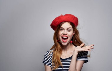 Kırmızı bereli ve çizgili tişörtlü kadın gri arka plan modeli.