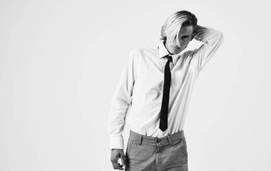 Tişörtlü ve kravatlı zarif bir genç arka planda kırpılmış bir manzara portresi