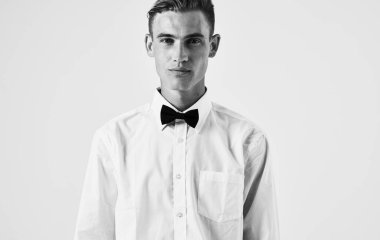 Açık arkaplan portresi üzerinde gömlek ve papyon giyen yakışıklı adam.