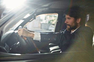 Takım elbiseli zengin adam araba kullanıyor. Başarılı bir yaşam tarzı.