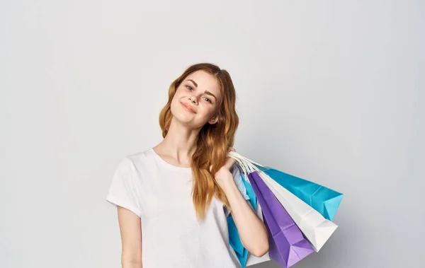 손으로 쇼핑하는 생활 방식을 포장 한 흰색 티셔츠를 입은 쾌활하고 아름다운 여성 — 스톡 사진
