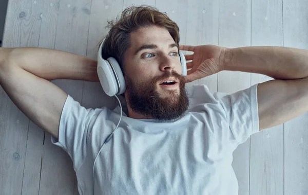 Γενειοφόρος άνδρας με ακουστικά ακούγοντας μουσική αναψυχή εσωτερικό τρόπο ζωής — Φωτογραφία Αρχείου