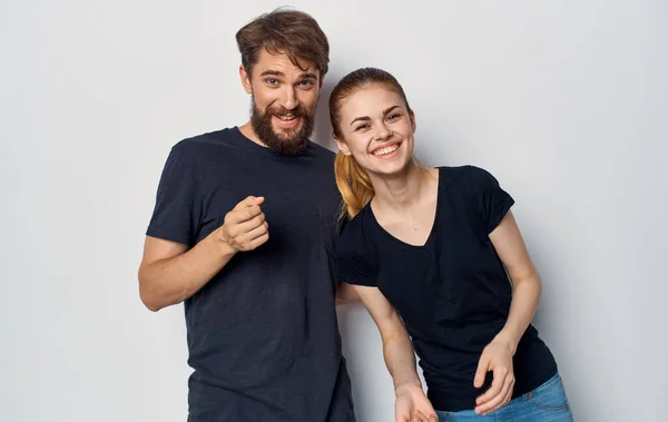 Mladý pár v černé trička zábava emoce ležérní oblečení studio — Stock fotografie