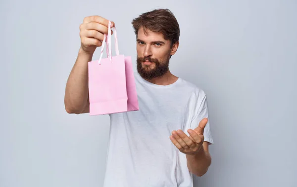 Modell férfi ajándék táska a kezében a könnyű háttér ünnepek — Stock Fotó