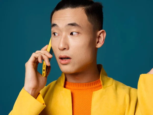 Een zakenman met een blauwe achtergrond praat aan de telefoon en kijkt naar de zijkant — Stockfoto