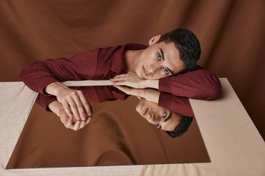 Gömlek aynalı adam katlı kumaş arkaplanı yansıttı