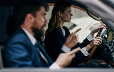 İş gezisinde iş arkadaşlarından birinin yanında araba süren bir kadın.