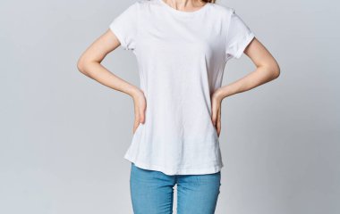 Beyaz tişörtlü ve kot pantolonlu bir kadın. Mankene el çabukluğuyla bakıyor.