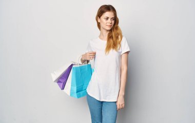 Neşeli bir kadın alışveriş paketlerini izole edilmiş bir stüdyoda tutuyor.