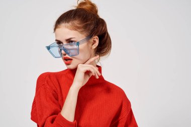 Mavi gözlüklü şık bir kadın. Parlak makyaj, kırmızı dudaklar.