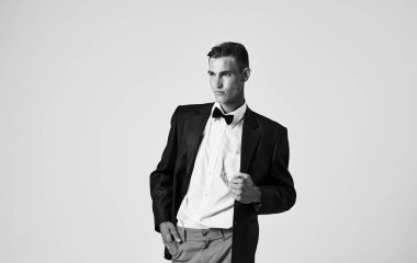 Siyah beyaz bir fotoğraf ceketli bir adam ve boynunda papyon var.