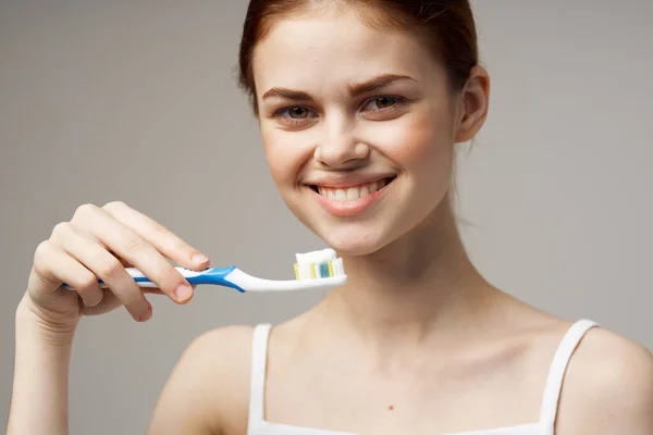 Mulher segurando uma escova de dentes com pasta em suas mãos cuidados dentários higiene close-up — Fotografia de Stock