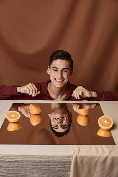 Man vid bordet med apelsiner och tyg bakgrund beskärd vy — Stockfoto